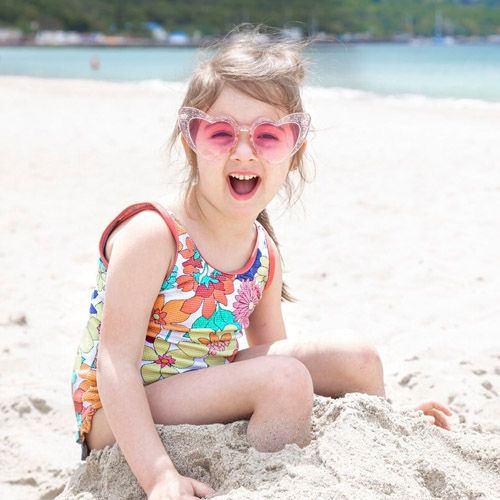 Niña jugando con arena en la playa