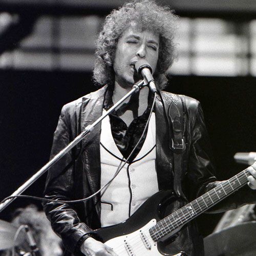 Una fotografía en blanco y negro de Bob Dylan actuando en el escenario.