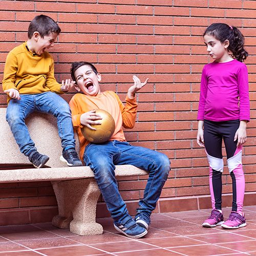 Niños burlándose de una niña como símbolo de violencia de género