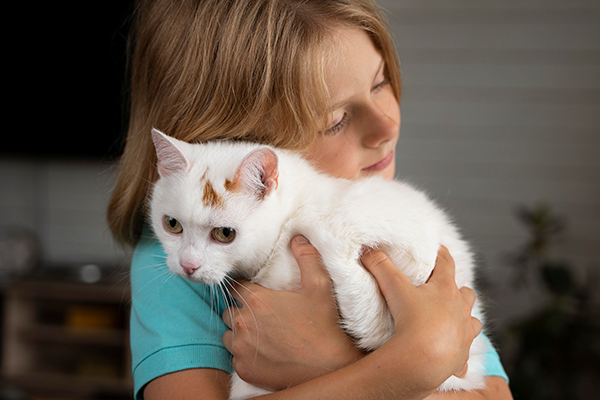 Niña abrazando a su gatito